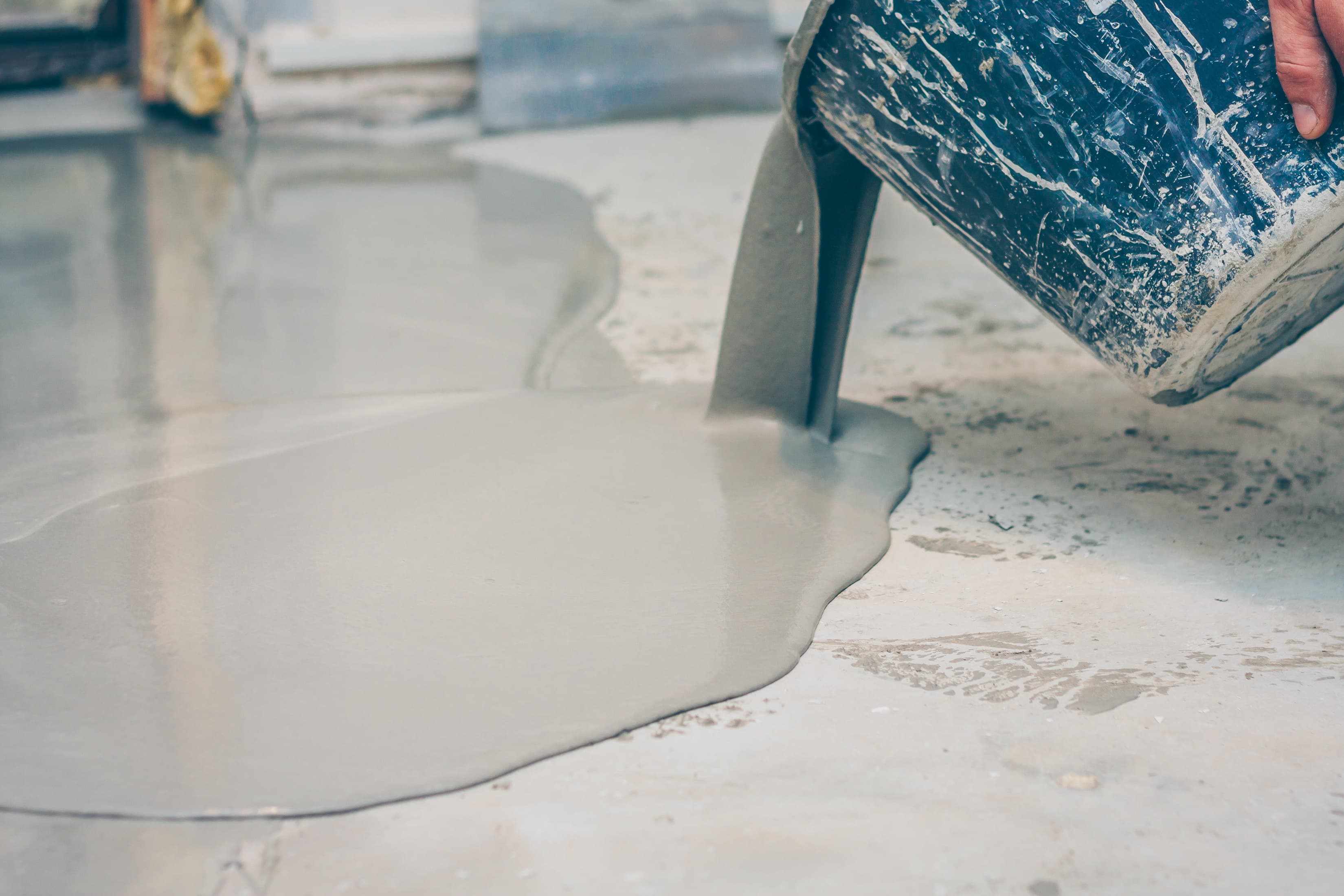 Epoxy being poured onto a garage floor during application
